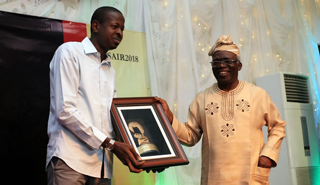 Abdulaziz Abdulaziz, 2018 WSCIJ-Nigerian Investigative Journalists of the Year (left) receiving his award from Femi Falana, human rights lawyer during the 13th Wole Soyinka Award for Investigative Reporting at NECA House, Alausa in Lagos.