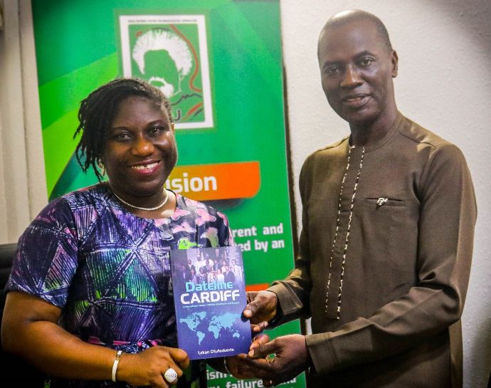 Alaka receives a signed copy of ‘Dateline Cardiff: Unforgettable media training experience and impact’ from Otufodunrin